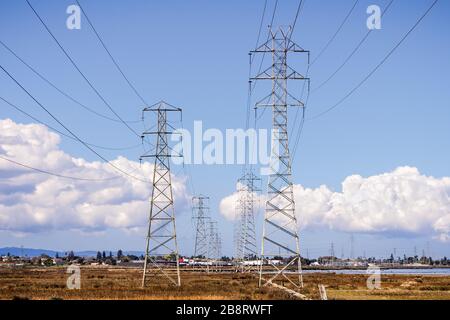 Torri elettriche ad alta tensione e linee elettriche sulle rive della Baia di San Francisco, Palo Alto, California Foto Stock