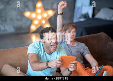 Due amici che giocano a calcio e sostengono la loro squadra Foto Stock