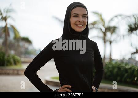 bella donna musulmana sport sorridente. donna sana con sciarpa esercizio Foto Stock