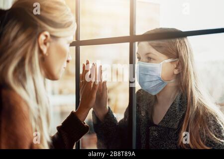 Madre e figlia sono separate a causa della quarantena Corona Virus Covid-19, sociale di distanza Foto Stock