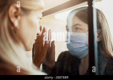 Madre e figlia sono separate a causa della quarantena Corona Virus Covid-19, sociale di distanza Foto Stock