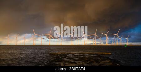 Parco eolico offshore a un bellissimo e spettacolare tramonto Foto Stock