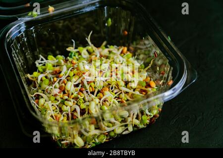 fagioli germogliati in scatola di plastica. dieta di alimento crudo. fuoco selettivo Foto Stock