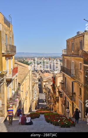 Una strada stretta tra le caratteristiche case di Caltagirone, una città in Sicilia in Italia Foto Stock