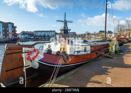 Paesi Bassi: Chiatta del fiume Haarlem con il mulino a vento De Adriaan sullo sfondo. Il mulino a vento originale risale al 1779. Foto Stock