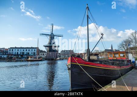 Paesi Bassi: Chiatta del fiume Haarlem con il mulino a vento De Adriaan sullo sfondo. Il mulino a vento originale risale al 1779. Foto Stock