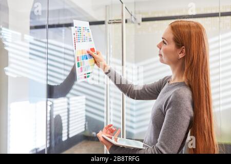 Giovane designer grafico che sceglie un colore per un progetto di design nell'agenzia di design Foto Stock