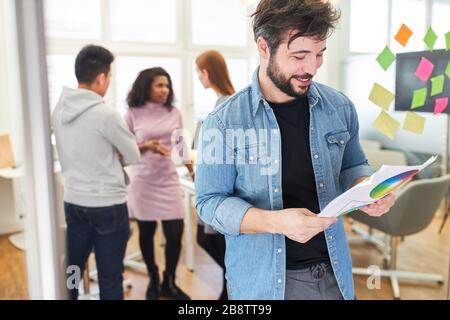 Progettista grafico o programmatore con ruota di colore in ufficio di un'agenzia internet Foto Stock