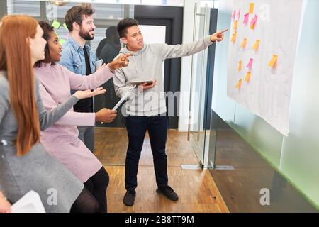 Squadra di progettista di fotoricettore di start-up al workshop di brainstorming che valuta le idee Foto Stock