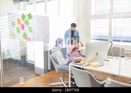 Tre giovani imprenditori in una riunione nell'ufficio della loro agenzia del Internet Foto Stock