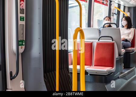 Centro di Sydney, Australia. Lunedì 23 Marzo 2020. Ragazze asiatiche adolescenti che indossano maschere facciali sul treno leggero di Sydney. Credit Martin Berry/Alamy Live News Foto Stock