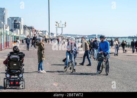 Folla di persone che ignorano i consigli del governo sull'autoisolamento passeggiando sul lungomare di Hove questa mattina. Foto Stock