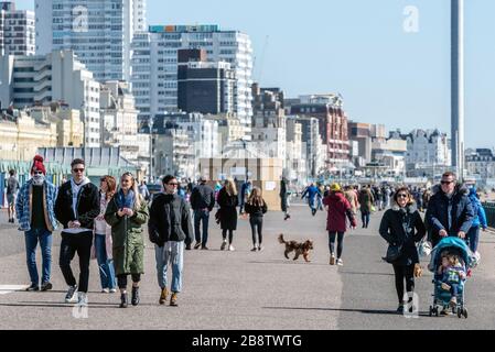 Folla di persone che ignorano i consigli del governo sull'autoisolamento passeggiando sul lungomare di Hove questa mattina. Foto Stock