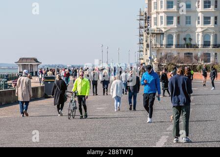 Folla di persone che ignorano i consigli del governo sull'autoisolamento passeggiando sul lungomare di Hove questa mattina. Foto Stock