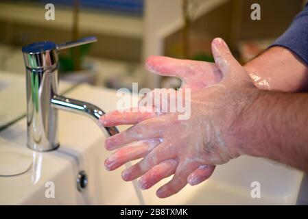 Lavare le mani regolarmente per 20 secondi per proteggere da Coronavirus COVID-19 Foto Stock