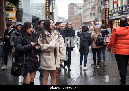 LONDRA, Regno Unito - 20 marzo 2020: Chinatown con persone non identificate in un giorno di pioggia. Chinatown e' parte dell'area di Soho con una gamma di ristoranti Cinesi Foto Stock