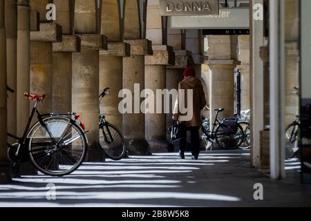 23 marzo 2020, Renania settentrionale-Vestfalia, Münster: Una donna attraversa il Prinzipalmarkt. Per rallentare la diffusione del coronavirus, il governo federale ha fortemente limitato la vita pubblica. Foto: Rolf Vennenbernd/dpa Foto Stock