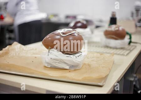 Fare il cioccolato. Preparare le uova di pasqua al cioccolato. Fabbrica di cioccolato. Foto Stock