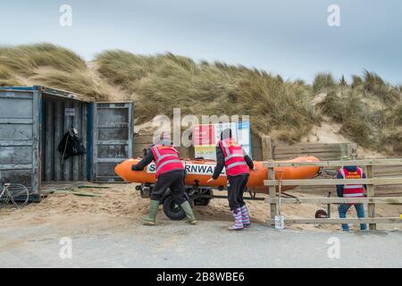 I membri del Newquay Surf Lifesaving Club caricano la LORO COSTOLA Lifesaving in un contenitore di stoccaggio a Fistral a Newquay in Cornovaglia. Foto Stock