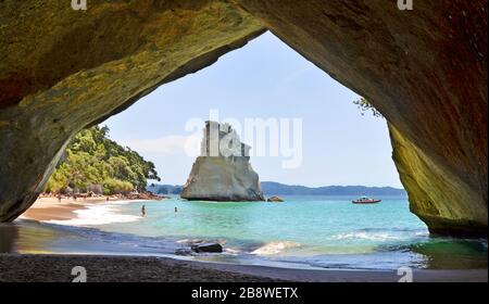 Guarda attraverso l'arco di roccia naturale verso la spiaggia di hahei nuova zelanda Foto Stock