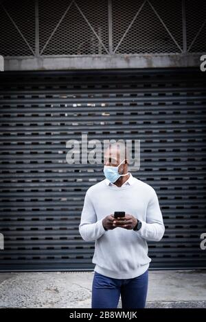 African American con maschera coronavirus covid19 in strada Foto Stock