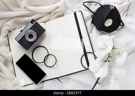 tempo di isolamento, malattia, fotocamera, notebook e maschera protettiva. soggiorno a casa. lavoro del fotografo durante la quarantena. quarantena e fotografia Foto Stock