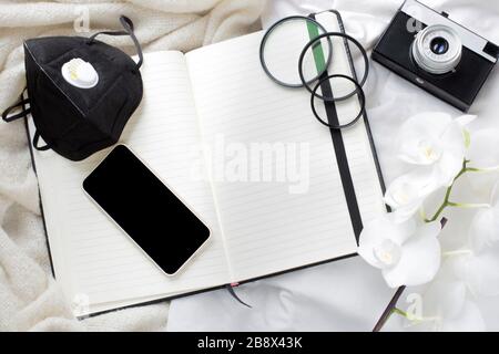 tempo di isolamento, malattia, fotocamera, notebook e maschera protettiva. soggiorno a casa. lavoro del fotografo durante la quarantena. quarantena e fotografia Foto Stock