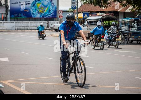 Vientiane, Laos. 23 marzo 2020. Un uomo che indossa la maschera per il viso guida una bicicletta per strada a Vientiane, Laos, 23 marzo 2020. La popolazione del Laos ha adottato misure preventive contro il COVID-19, nonostante non vi siano casi confermati di infezione da virus in Laos. Credit: Kaikeo Saiyasane/Xinhua/Alamy Live News Foto Stock