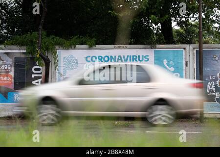 Buenos Aires, Deutschland. 17 Marzo 2020. Un'auto passa davanti a un cartello che dice Cotonavirus. | utilizzo nel mondo credito: dpa/Alamy Live News Foto Stock