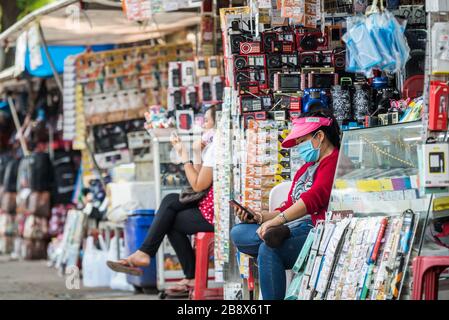 Vientiane, Laos. 23 marzo 2020. I velieri che indossano maschere facciali attendono i clienti lungo la strada a Vientiane, Laos, 23 marzo 2020. La popolazione del Laos ha adottato misure preventive contro il COVID-19, nonostante non vi siano casi confermati di infezione da virus in Laos. Credit: Kaikeo Saiyasane/Xinhua/Alamy Live News Foto Stock