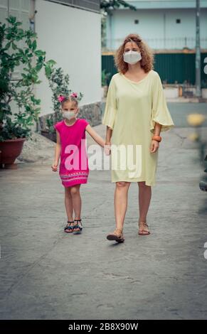 Donna e figlia che indossano maschera facciale monouso per evitare infezioni virali. Protezione da coronavirus Foto Stock