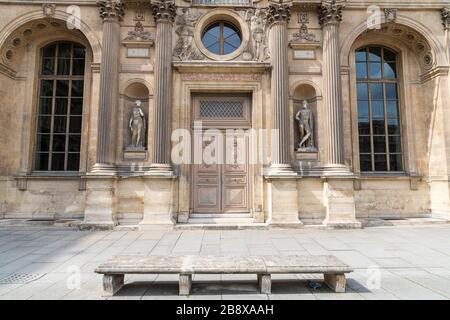 Antiquariato in legno intarsiato porta con pietra intagliata nella struttura di un antico palazzo a Parigi. Foto Stock