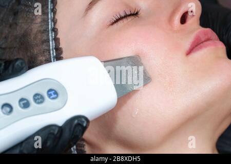 pulizia del viso con un dispositivo a ultrasuoni Foto Stock