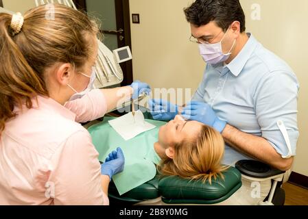 Dentista facendo un trattamento dentale di un paziente Foto Stock
