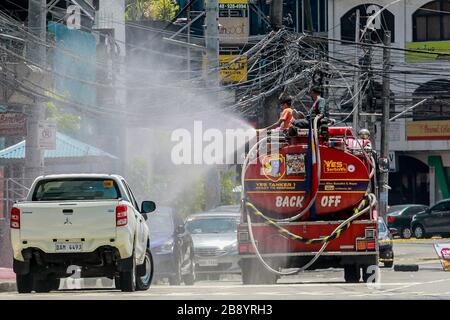 Quezon City, Filippine. 23 marzo 2020. Vigili del fuoco su un disinfettante spray camion fuoco su una strada a Quezon City, Filippine, 23 marzo 2020. Il numero di casi COVID-19 nelle Filippine è salito a 462, il Dipartimento della Salute del Paese (DOH) ha detto lunedì. Il DOH ha detto in un rapporto che 33 persone sono morte per la malattia altamente infettiva, mentre 18 si sono guariti. Credit: Rouelle Umali/Xinhua/Alamy Live News Foto Stock