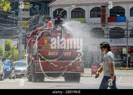 Quezon City, Filippine. 23 marzo 2020. Vigili del fuoco su un disinfettante spray camion fuoco su una strada a Quezon City, Filippine, 23 marzo 2020. Il numero di casi COVID-19 nelle Filippine è salito a 462, il Dipartimento della Salute del Paese (DOH) ha detto lunedì. Il DOH ha detto in un rapporto che 33 persone sono morte per la malattia altamente infettiva, mentre 18 si sono guariti. Credit: Rouelle Umali/Xinhua/Alamy Live News Foto Stock