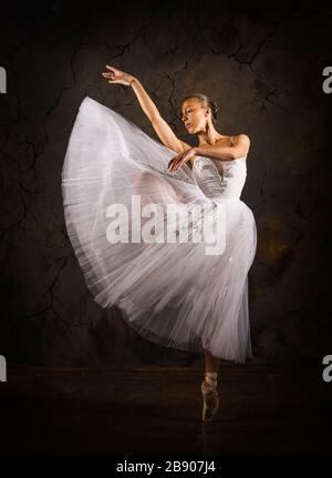 Donna snella in un corset bianco tutu balletto da ballo. Riprese in studio su sfondo scuro, immagini isolate. Foto Stock