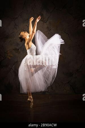 Donna snella in un corset bianco tutu balletto da ballo. Riprese in studio su sfondo scuro, immagini isolate. Foto Stock