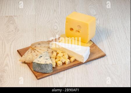 Diversi tipi di formaggio Roquefort, formaggio di noce, brie, su un asse di legno. Foto Stock