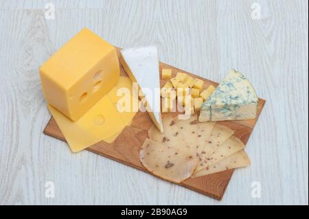 Diversi tipi di formaggio Roquefort, formaggio di noce, brie, su un asse di legno. Foto Stock