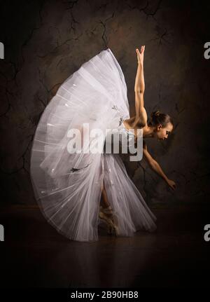 Donna snella in un corset bianco tutu balletto da ballo. Riprese in studio su sfondo scuro, immagini isolate. Foto Stock