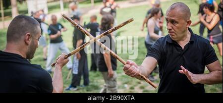 Un grande gruppo di studenti pratica filipino eskrima arnis bastone tecniche di lotta su kapap arti marziali seminario Foto Stock