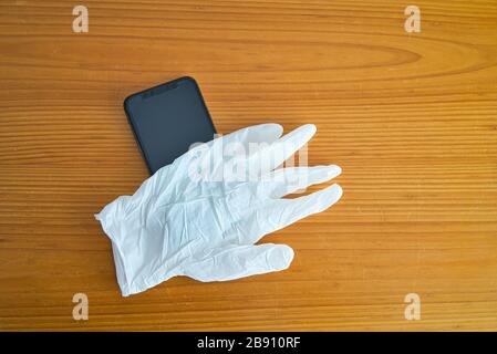 Guantes de látex blancos para proteger el uso del teléfono inteligente contra el Covid-19. Coronavirus, virus y enfermedades contagiosas. Protéjase cu Foto Stock