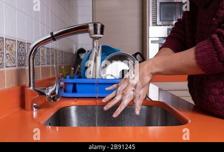 donna che lava le mani in cucina Foto Stock