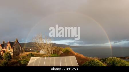 Arcobaleno sopra il villaggio di Carradale, Kintyre, Argyll e Bute, Scozia Foto Stock