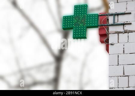 Farmacia urbana o negozio di droga segno, 24 ore croce segno verde di farmacia, LED display croce verde sul muro nella strada della città, copia Foto Stock