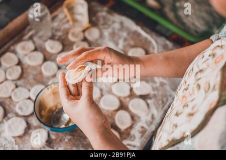 Un piatto ucraino magro, una donna in cucina prepara gnocchi con patate.2020 Foto Stock