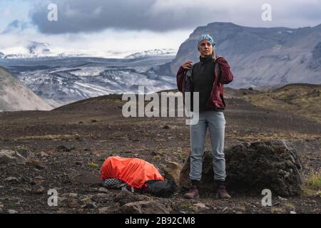 Backpacker Layering Up to evitare Storm in Islanda Highlands Foto Stock