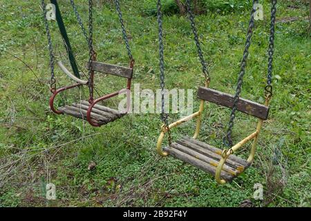 Posti a sedere in legno vintage nel parco giochi in disuso. Foto Stock