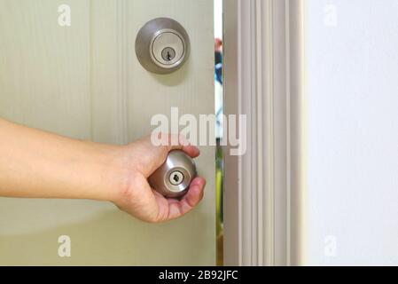 Maniglia di mano dell'uomo per aprire la porta Foto Stock